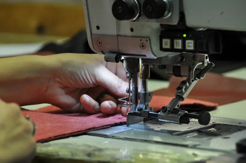 Hands guiding fabric under a sewing machine